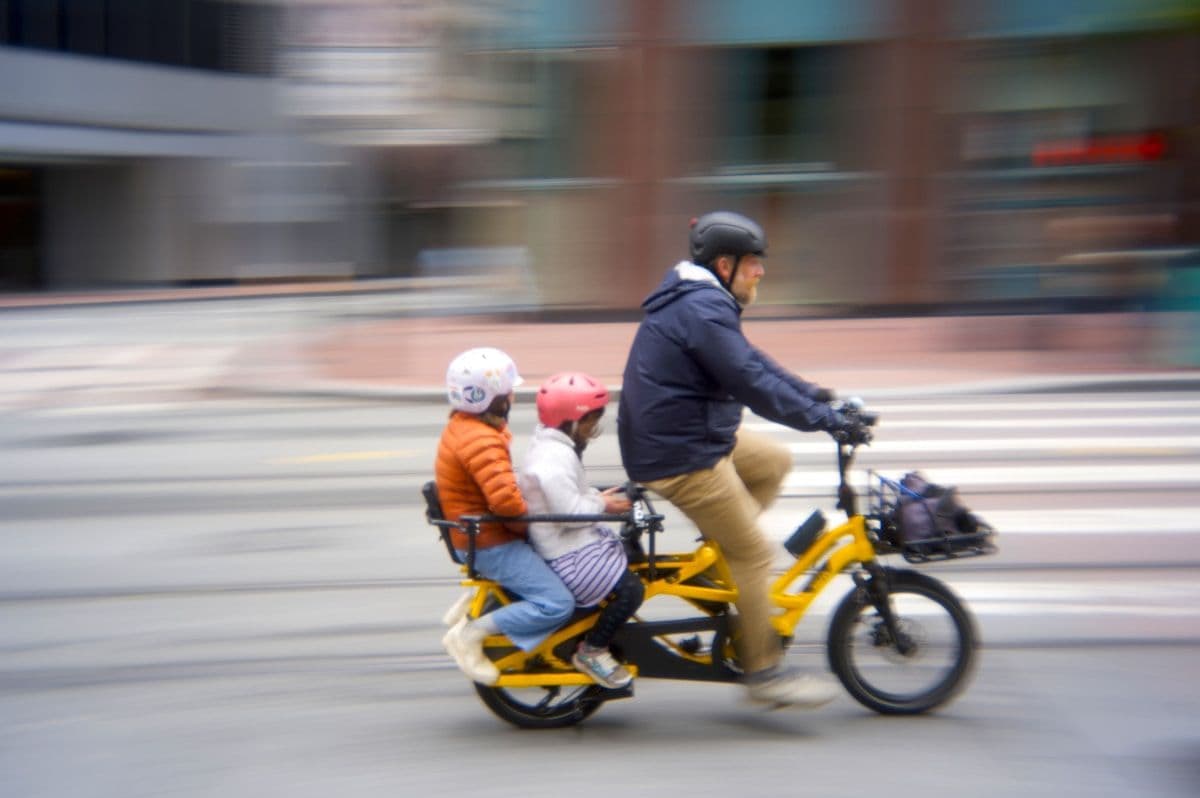 Gezin rijdt op een bakfiets door de stad